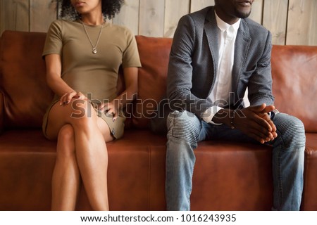 African american unhappy couple sitting on couch after quarrel fight thinking of break up or divorce, black upset man and woman not talking having conflict, bad relationships concept, close up view Royalty-Free Stock Photo #1016243935