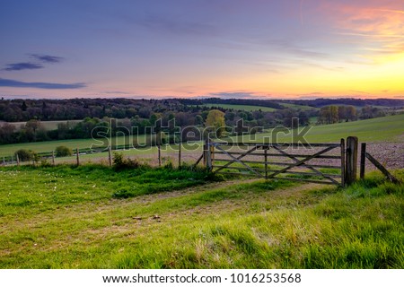 Sunset over field gate in the Chess Valley, Part of the Chiltern Hills.  Royalty-Free Stock Photo #1016253568