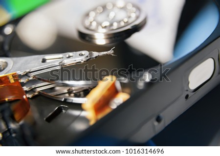 Macro view of an HDD head resting on a disk platter and its reflection