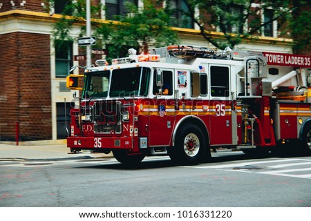 NYC Firetruck driving on a road Royalty-Free Stock Photo #1016331220