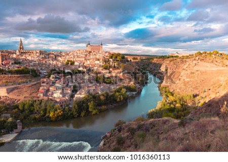 Panoramic aerial view of Old city of Toledo with Cathedral, Alcazar and river Tajo at dusk, Castilla La Mancha, Spain