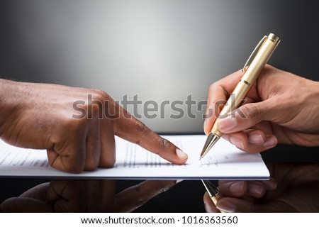 Pointing The Finger In Front Of A Person Signing With Golden Pen On The Document