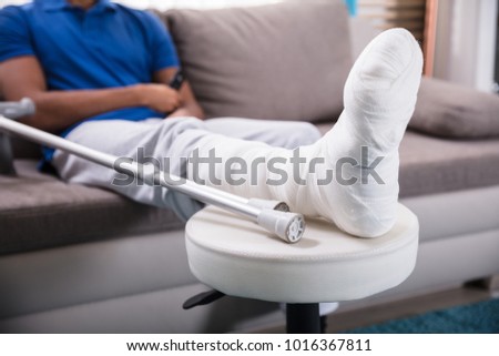 Close-up Of A Man's Broken Leg And Crutches Royalty-Free Stock Photo #1016367811
