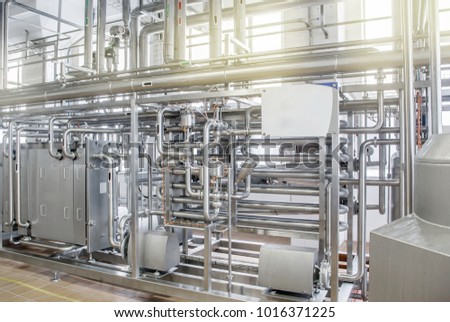 Pipelines from stainless steel, a system for pumping liquids or milk for the food industry. Abstract industrial background.