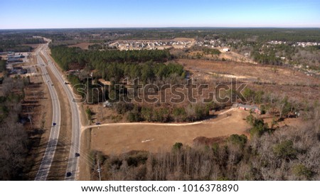 Aerial view of houses and land along a road