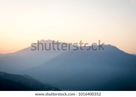 sunset in the mountains, the tops of the mountains in mist and sunlight