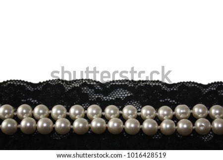 Beautiful top view detail of black lace and pearl beads on empty white background