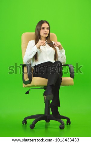 The businesswoman sitting on the green background