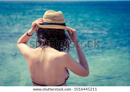 Beach vacation. Beautiful woman in sunhat and bikini looking at the beach on a hot summer day. Photo from Fuerteventura Island, Spain