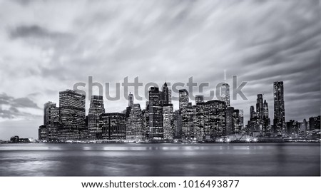 Lighting up time in Manhattan with the skyline viewed from Brooklyn, New York. A long black and white exposure captures the fading natural light with the buildings coming to life. 