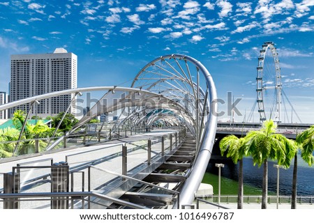 Singapore city landscape at day blue sky. Pedestrian DNA bridge and ferris wheel Flyer at Marina Bay view. Urban cityscape Royalty-Free Stock Photo #1016496787