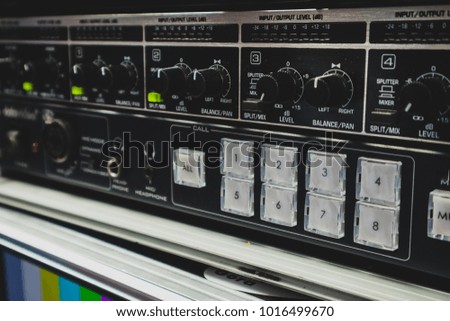 Knobs dials and buttons on an audio mixing table. Rack with audio mixer on a tv production studio.