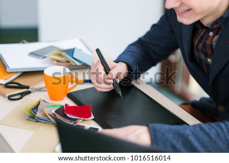 fashion designer sketching on graphic tablet. Creation of new clothes. Unique ideas, unusual designs. Fabric samples