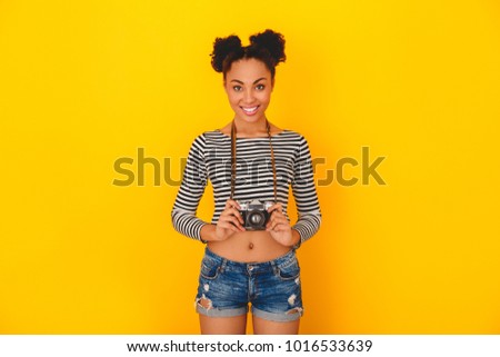Young african woman isolated on yellow wall studio teen style photographer