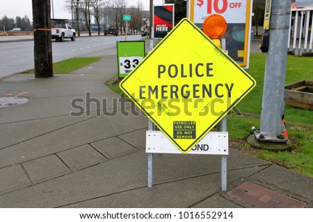 A sign in English stating to the public that there is a police emergency in the area. 
