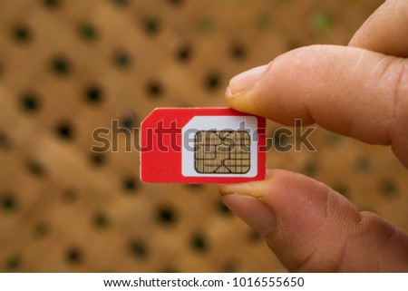 Fingers holding a cellphone SIM card 