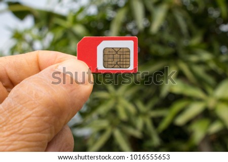 Fingers holding a cellphone SIM card 