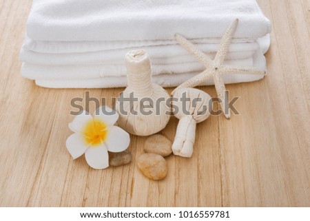 Spa ball with towel, oil frangipani with on wooden board background
