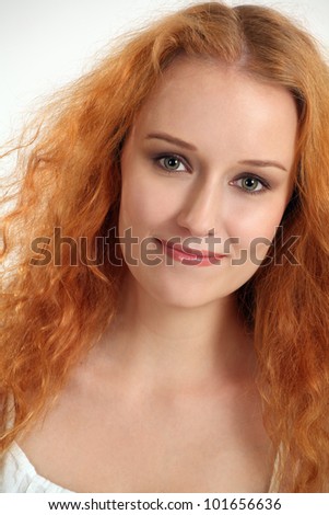 Photo of the face of a gorgeous young female with red curly long hair.