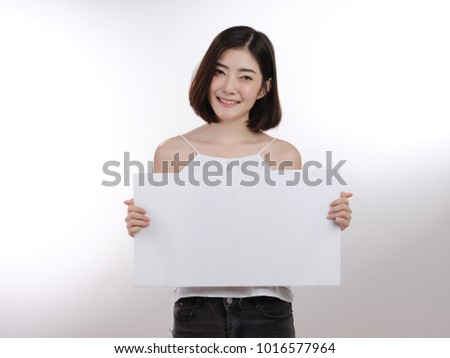 smiling happy  young Asian woman   with big white poster on isolated background