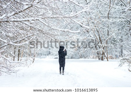 Girl takes a winter forest on the phone