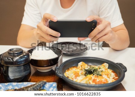 Close-up Man's hands use pointing finger Mobile smart Phone take photo Food on table, technology and home concept