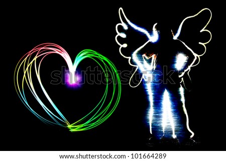 angel and heart shape drawing by flashlight multiple color in the night