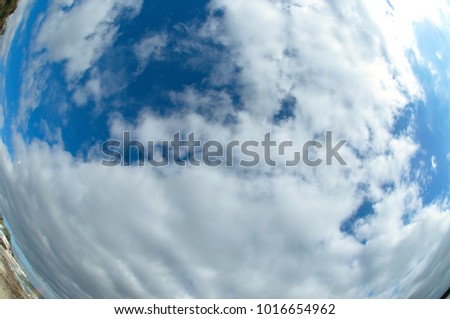 bright blue sky with fluffy clouds on the fish-eye lens. fluffy clouds in the blue sky