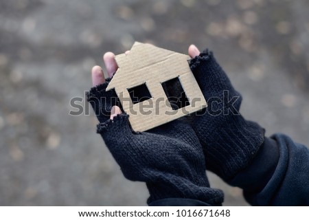 young homeless boy holding a cardboard house Royalty-Free Stock Photo #1016671648