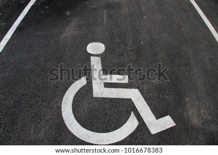 Handicap icon. Parking lot with handicap sign and symbol. Empty handicapped reserved parking space with wheelchair symbol. Disabled person sign. Copy space