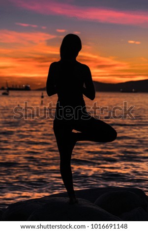 silhouette of girl and doing yoga on the beach with sunset backgrounds