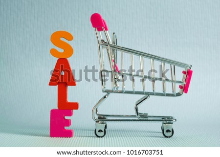 Sale colorful wooden text and shopping cart or supermarket trolley on blue background with copy space, shopping discount and merketing concept idea. template for add text or photo.