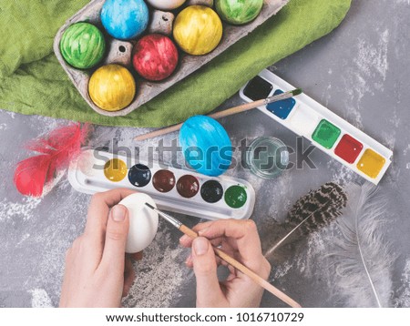 Young mother painting Easter eggs. Preparing for Easter