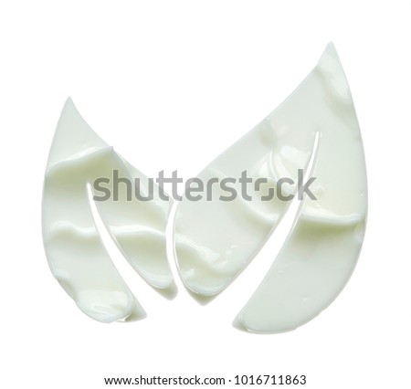 Textures of white cream for face in the shape of a flower leaf on white background