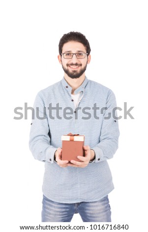 A portrait of a young man smiling and holding a small brown gift, isolated on a white background.