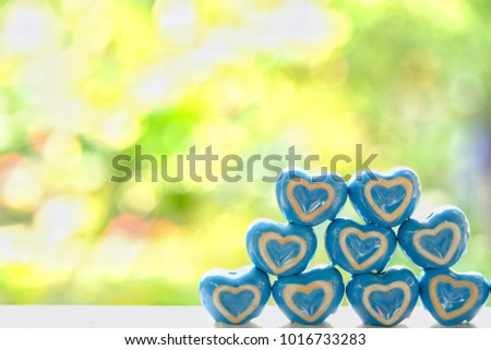 little ceramic in shape of hearts with green space background for valentine’s day.