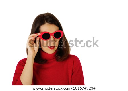 Young woman in red turtleneck and sunny red glasses on isolated background. Selective focus.