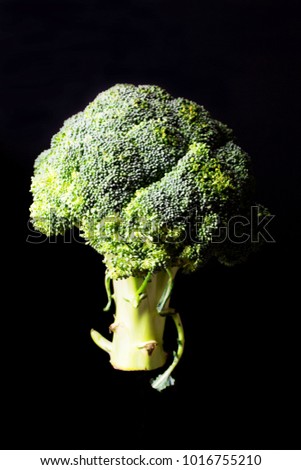 Broccoli on a black background, vertical