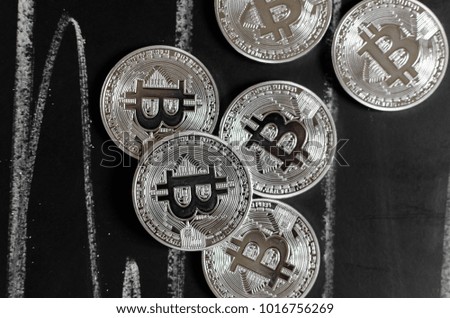 Bitcoin on a school board, Bitcoin replica on black chalkboard,lots silver coins