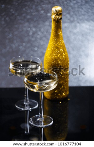 Photo of bottle of wine and two wine glasses on black table