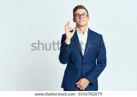 business man with glasses smiling showing thumbs up signs on a light background                               