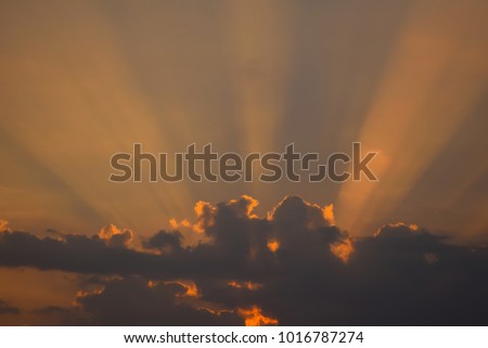Beams of the sun shine through the clouds before morning or evening.