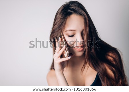 Girl calling on phone. Beautiful woman uses a smartphone on a white background.