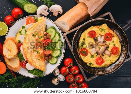 A set of omelets with vegetables, mushrooms and chicken. On a wooden background. Top view. Copy space.