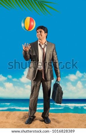 Indian/Asian young businessman relaxing at beach