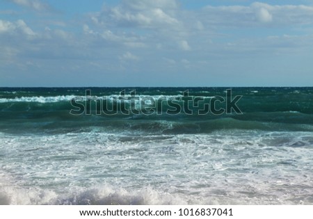 Azur sea water with blue waves, wind and  white foam on the waves Sea coast Picolo Pevero, Sardinia, Italy