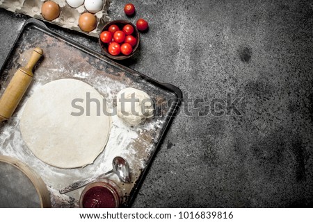 Roll up dough with ingredients for pizza. On a rustic background.