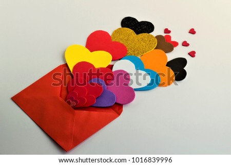 Many colorful hearts take out from a red envelope,on the white background.Concept for special celebrations.