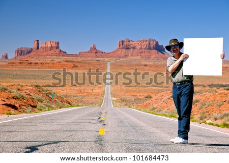 man holding sign on highway to monument valley, utah