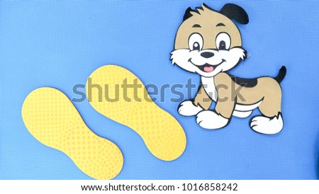 Footprints and dog figurines placed on a blue background.